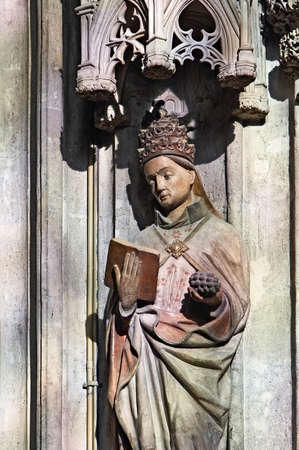  Statue of saint in a color light through a stained glass gothic window in Stephansdom Vienna