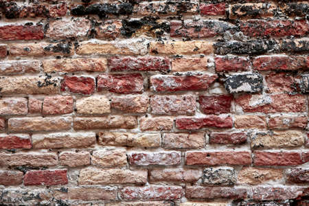 The weather worn red brick wall texture