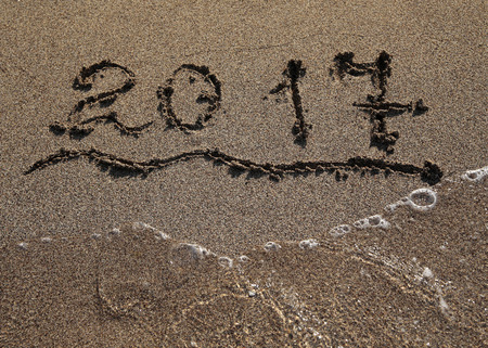 2017 new year numbers on beach sand washed by the sea waveの写真素材