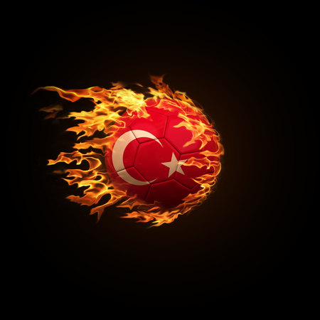 A soccer ball with the flag of Turkey burning with fire flies on a black background 3d renderの写真素材