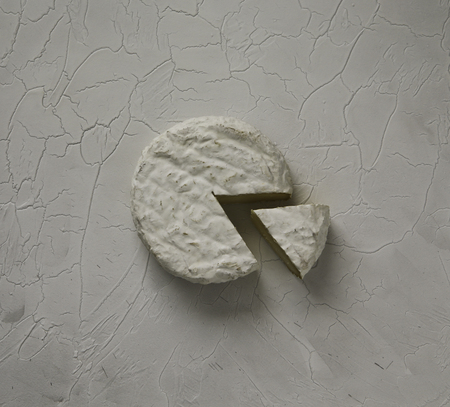 Ripe tasty cheese camembert or brie on a cracked table top viewの写真素材