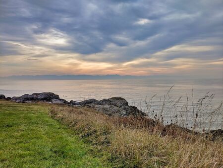 Rocky coastal shoreline of Friday Harbor in San Juan Island, WA, on an overcast day