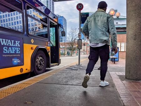 Bellevue, WA / USA - circa December 2019: Man exiting a King County Metro bus at Bellevue Transit Center downtown.のeditorial素材