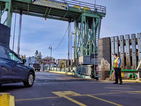 San Juan Island, WA / USA - circa November 2019: Man directing vehicle traffic off of a Washington...