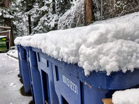 Seattle, WA / USA - circa January 2020: Snow and ice covered blue recycling trash cans in a neighborhood after a heavy snowfall.のeditorial素材