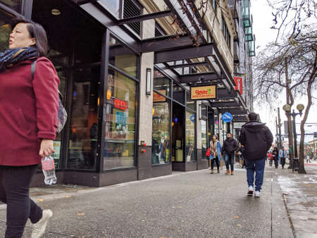 Seattle, WA / USA - circa November 2019: People walking by the entrance of a Qdoba Mexican...