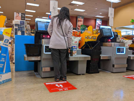 Kirkland, WA / USA - circa March 2020: Signs instructing social distancing at the self checkout...