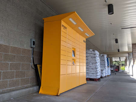 Kirkland, WA / USA - circa May 2020: Street view of a set of bright yellow Amazon parcel lockers...