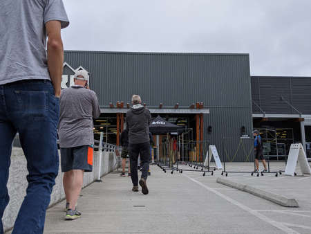 Bellevue, WA / USA - circa June 2020: People wearing masks lined up outside at REI Outdoor Store.のeditorial素材