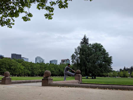 Bellevue, WA USA - circa June 2020: Man stretching his body before an afternoon run at Bellevue...