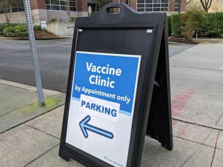 Redmond, WA USA - circa March 2021: Street view of a sign pointing out the way to a Vaccine Clinic in King County, WA.のeditorial素材
