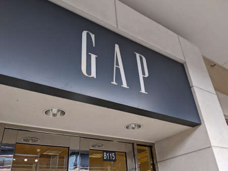 Redmond, WA USA - circa March 2021: Low angle view of the front of a Gap retail clothing store in an outdoor shopping mall.のeditorial素材
