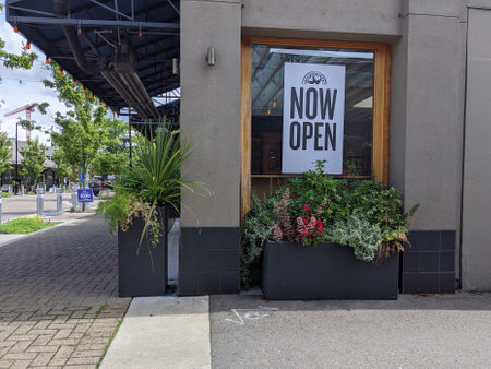 Kirkland, WA USA - circa June 2020: Side view of a Now Open sign on a restaurant window in downtown...