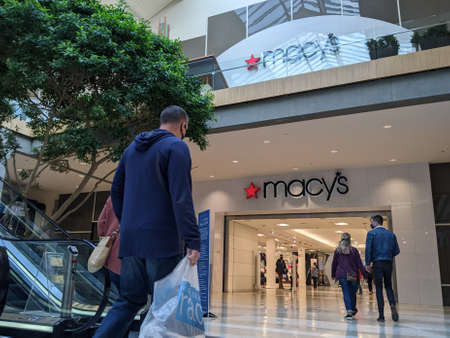 Bellevue, WA USA - circa March 2021: Shoppers with face masks approaching the entrance of a Macy's department store inside the Bellevue Mall.のeditorial素材