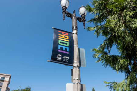 Tacoma, WA USA - circa August 2021: Low angle view of a Tacoma Pride banner on a lamp post in the downtown area.のeditorial素材