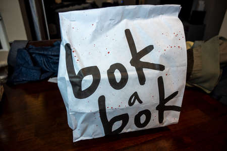 Seattle, WA USA - circa December 2021: View of a takeaway bag from Bok A Bok fried chicken restaurant on a dining room table.のeditorial素材