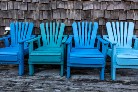 Set of matching blue chairs on a beachfront property patio on a clear dayの写真素材