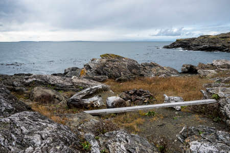 Gorgeous view of the grassy, rocky coastline on San Juan Island on a bright, sunny day with puffy white cloudsの写真素材