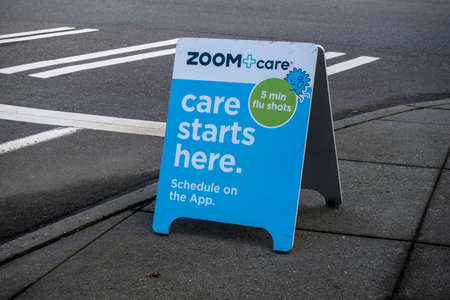 Woodinville, WA USA - circa February 2022: Angled view of a sandwich board on a sidewalk, advertising Zoom + Care just around the corner.のeditorial素材