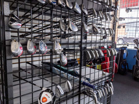 Woodinville, WA USA - circa June 2021: Angled view of gently used golf clubs for sale inside a Play It Again Sports store.のeditorial素材