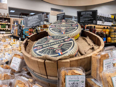 Woodinville, WA USA - circa April 2022: Angled view of a large cheese wheel and crackers for sale inside a Haggen Northwest Fresh grocery store.のeditorial素材