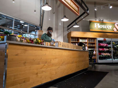 Lynnwood, WA USA - circa April 2022: Angled view of a florist working inside a Town and Country grocery store.のeditorial素材