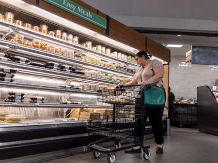 Mill Creek, WA USA - circa May 2022: View of a woman shopping in the deli and easy meals section of...