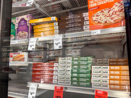 Mill Creek, WA USA - circa May 2022: Angled view of a variety of frozen pizzas for sale inside the freezer section of a Town and Country Market.のeditorial素材