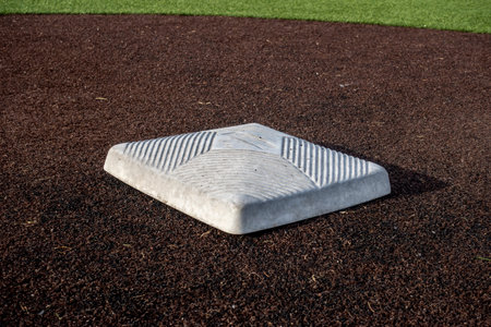 close up view of a base on a clean baseball field on a bright, sunny day