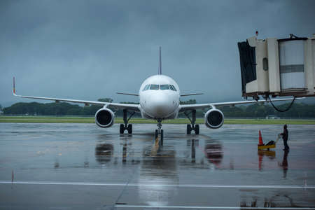 Airplane parking at the airport bay in the rainy dayの写真素材