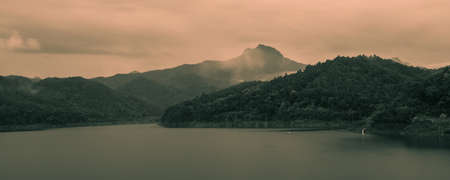 panorama landscape scene of mountain, lake and cloud with people fishing at morning time in tropical...