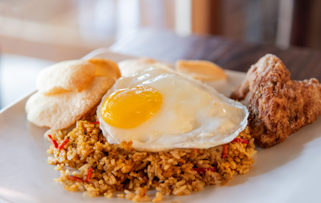 Chilly fried rice with sunny side egg up on white plate. Traditional indonesia and asian food. Selective focus.の写真素材