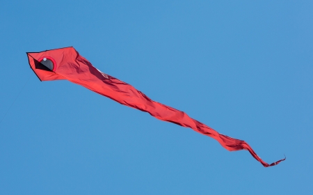 Colourful kite against vibrant blue skyの写真素材