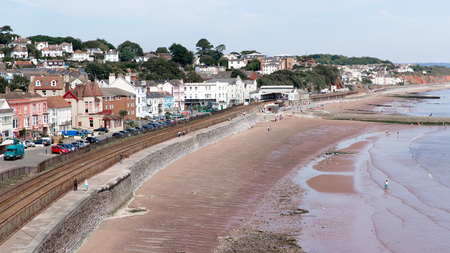 Dawlish Devon England with beach railway track and sea on blue sky summer dayのeditorial素材