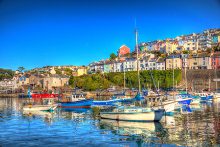 Brixham harbour Devon with houses on the hillside and colourful boats moored on a still summer calm summer day with blue sky a traditional English coast scene の写真素材