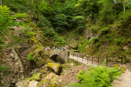 Tourists at Aira Force waterfall in Ullswater Valley Lake District, Cumbria, England in beautiful woodland with bridgeのeditorial素材