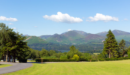 View from Castlerigg Hall Keswick Lake District Cumbria to Derwent Water and Catbells mountains and fells on a summer day with blue sky and sunshineの写真素材