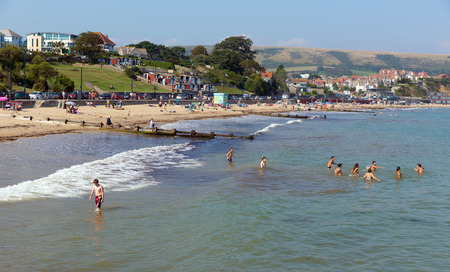 Swimming in the sea Swanage beach Dorset England UK near Poole and Bournemouth at the eastern end of the Jurassic Coast a World Heritage Site popular south coast tourist destinationのeditorial素材