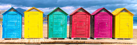 Spanish beach huts panoramic view with bright colours with red green blue yellow purple coloursの写真素材