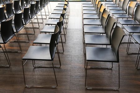 Rows of empty chairs prepared for an indoor event. Empty chairs in a modern conference room. Shallow...