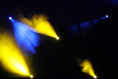 Blue and yellow colored light show over concert stage