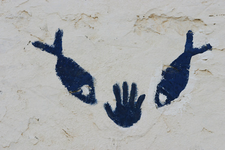  Close up picture of a hand and fish symbol on traditional berber house wall in the saharaの写真素材