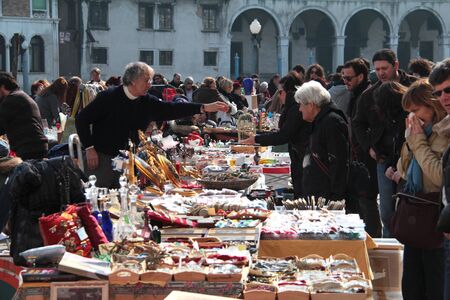 VENICE, ITALY - MARCH 12, 2011: Unknown people shopping at a flea market on the street in Venice...
