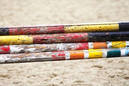 Colorful jump obstacles for equestrian sports outdoors against sandy trackの写真素材