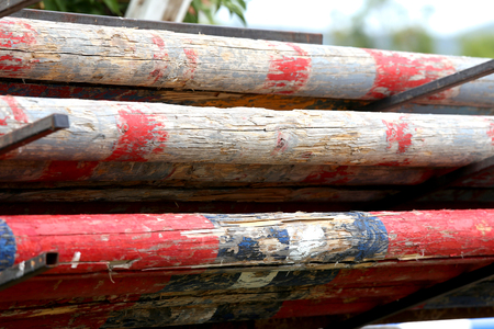 Image of show jumping poles stacked at the show jumping arena. Old retro wooden barriers on the ground for jumping horses as a backgroundの写真素材