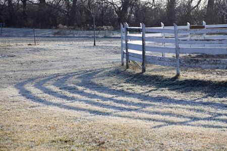 Round pen for horse exercise and training on frosty morning wintertime in sunrise. Against morning...