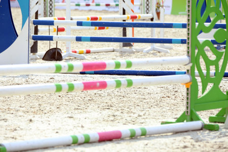 Show jumping poles obstacles, barriers, waiting for riders on show jumping training. Horse obstacle course outdoors summertime. Poles in the sand for equestrian eventsの写真素材