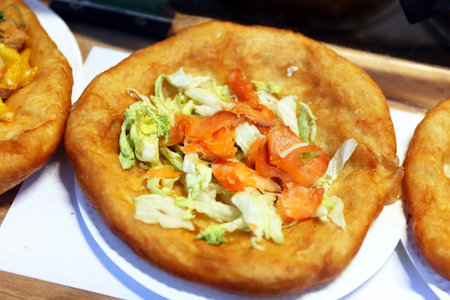 Freshly baked traditional hungarian langos langosch langosh with salmon and salad for sale. Gastronomy backgroundの写真素材