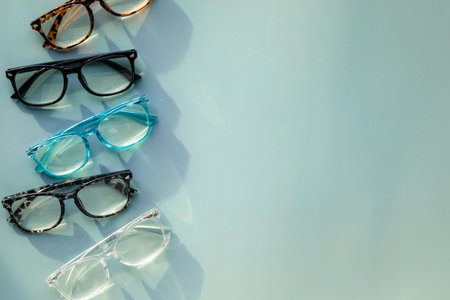An Assortment of Blue Light Blocking Reading Glasses on Light Blue Solid Background with Copy Spaceの写真素材