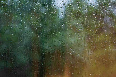 Water droplets on a window. Blurry blue and green background. Picture from Scania, southern Sweden